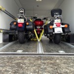 Three motorcycles securely strapped down